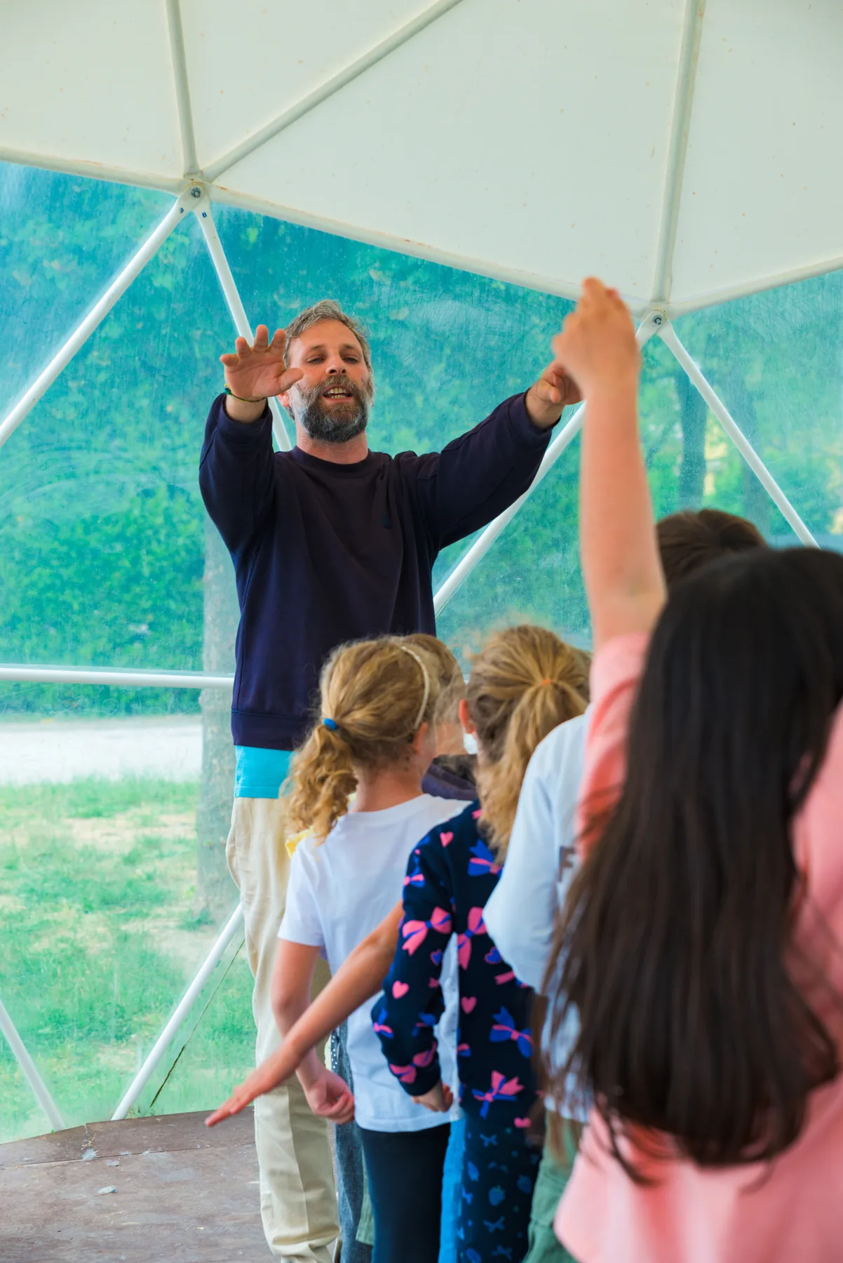 Stefano guida un gruppo di bambini durante un'attività musicale.